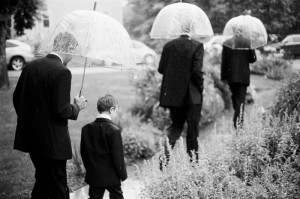 Groomsmen and ring bearer walking through a garden in the rain prior to a wedding at the Chautauqua Community House in Boulder, CO.